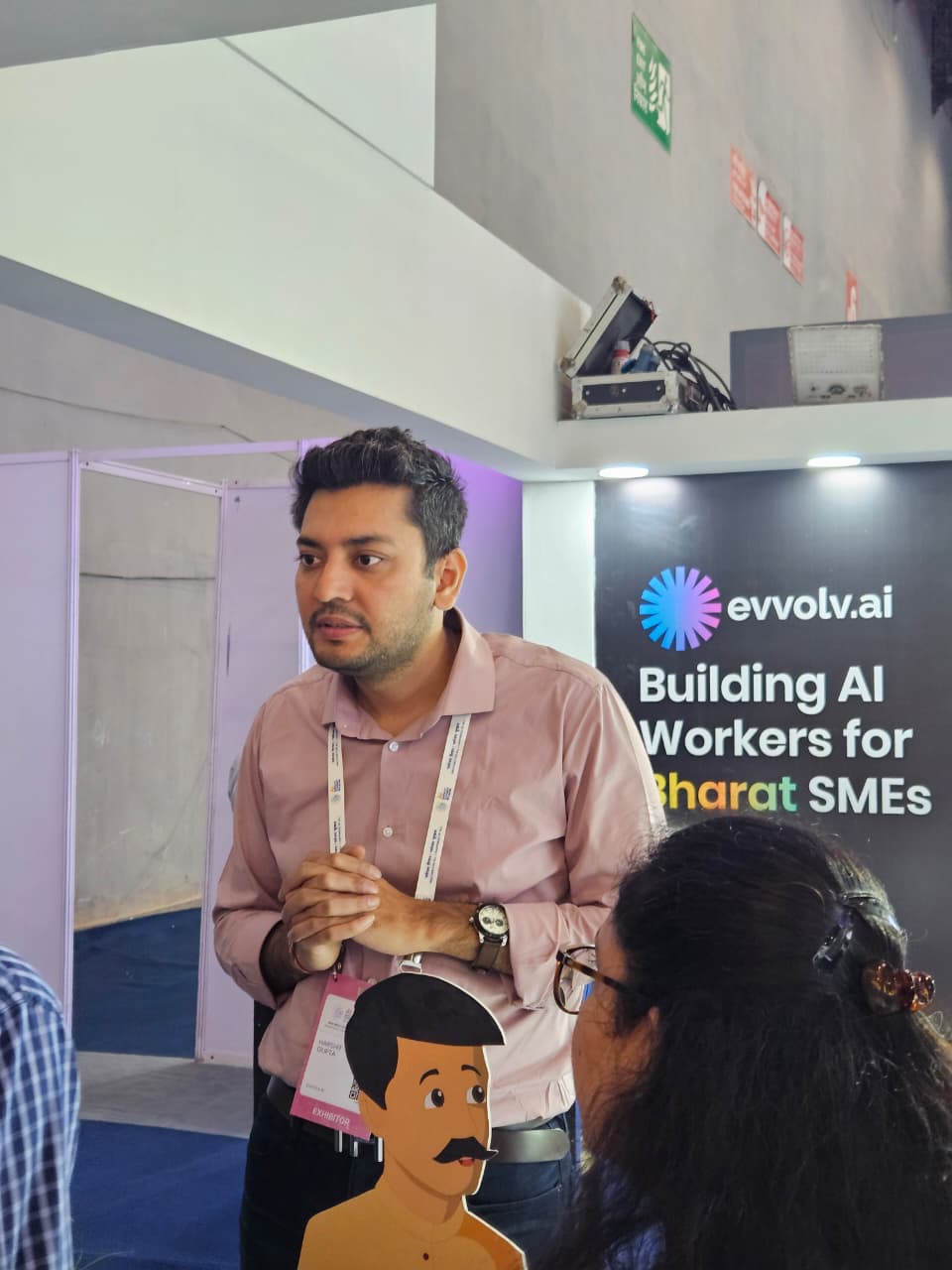Harshit talking with visitors at the booth